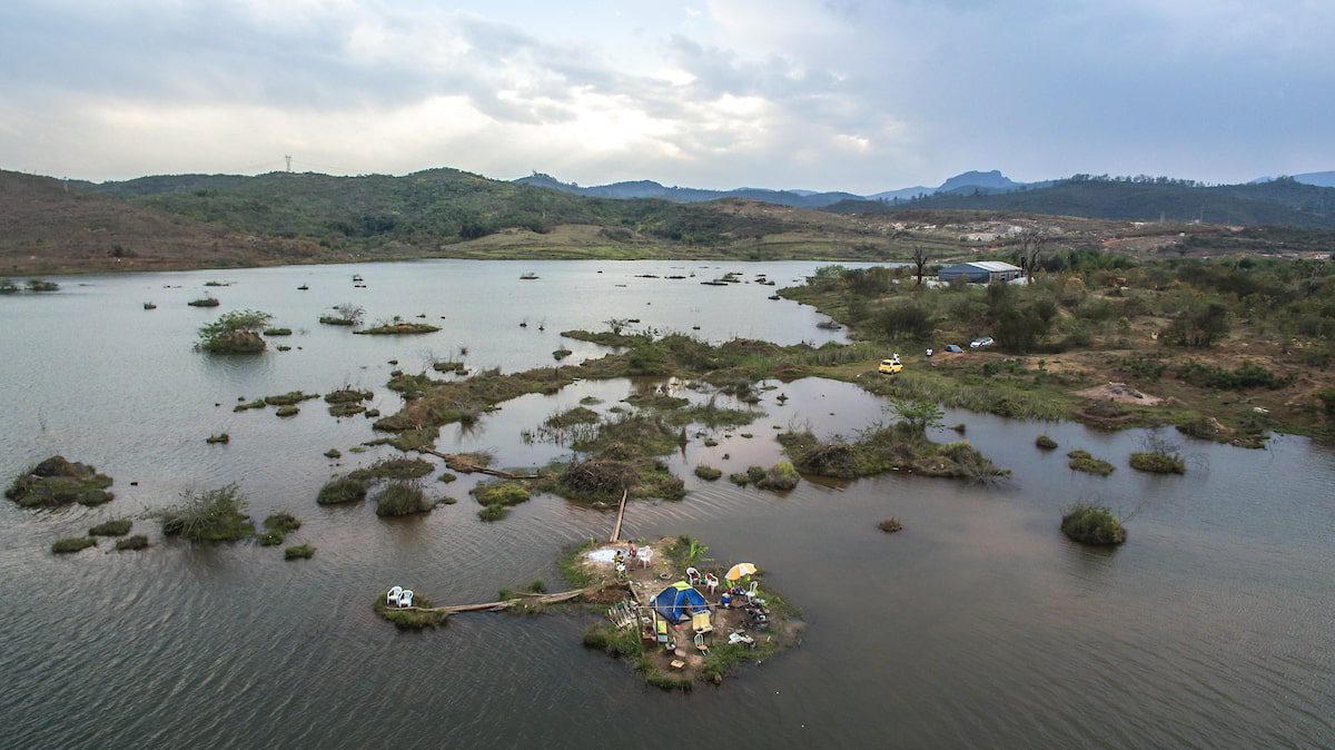 Uma vista aérea de um lago com uma casa sobre ele.