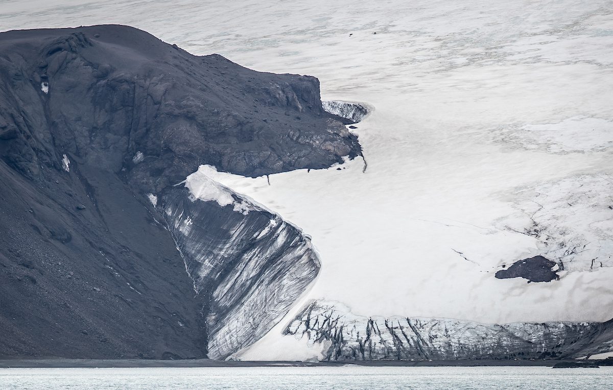 Imagem de um grande glaciar no meio de uma montanha.