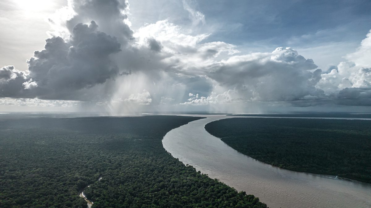 Imagem da vista aérea de um rio e nuvens.