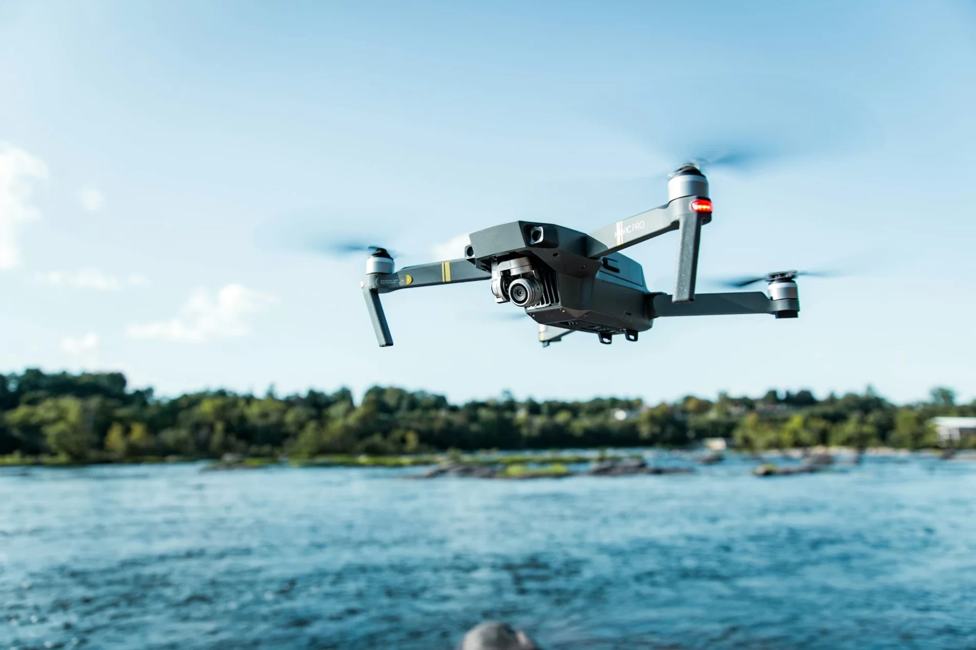 Imagem de drone sobrevoando o mar com paisagem de floresta de fundo