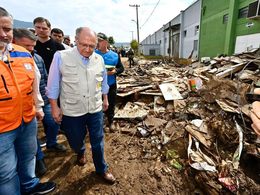 Imagem de políticos visitando deslizamento.