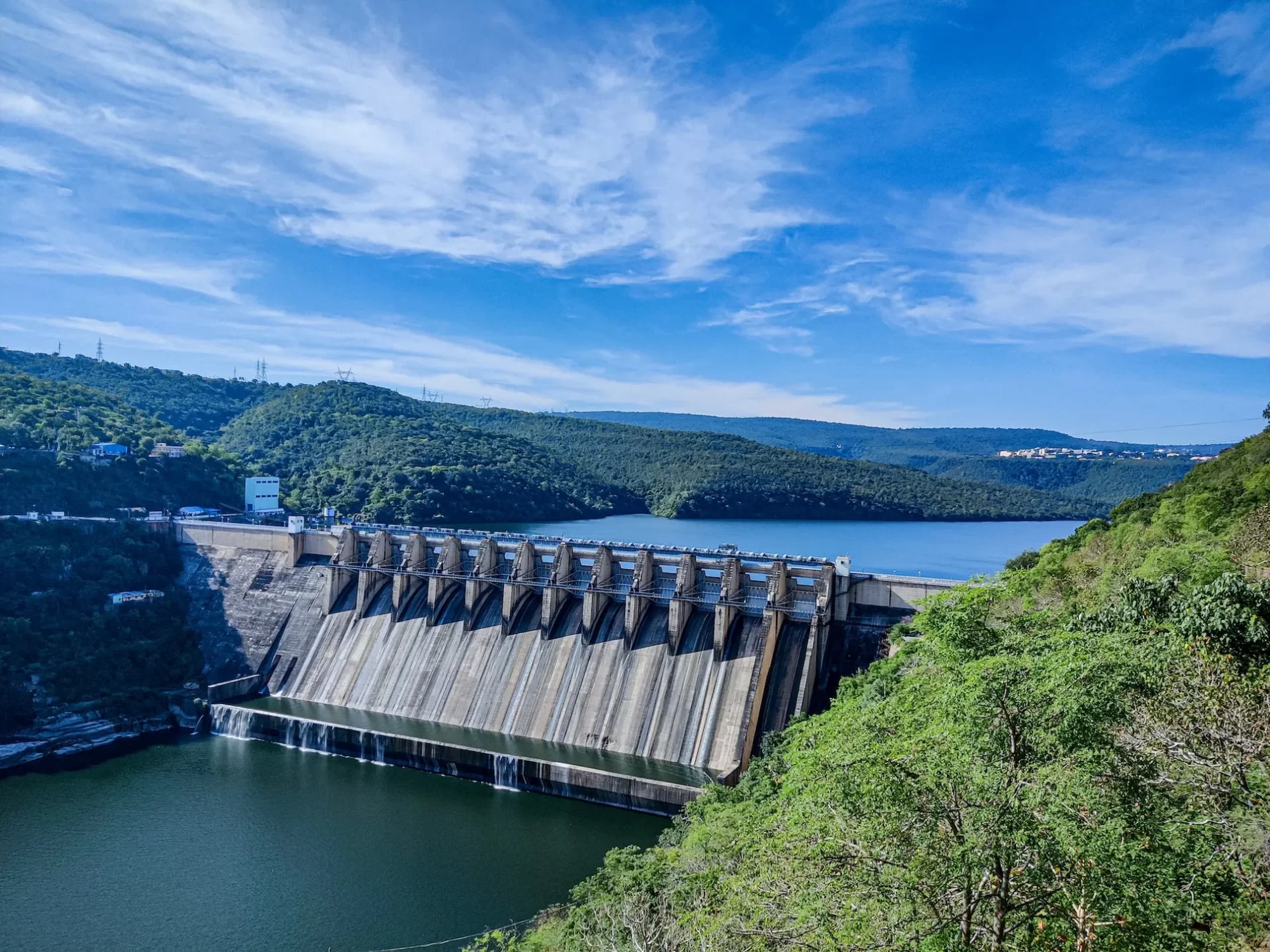 Barragem de concreto cinza sob o céu azul durante o dia