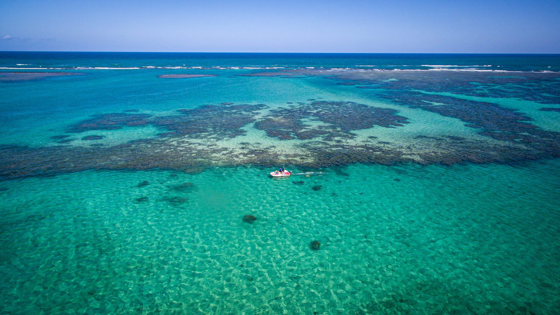 Uma vista aérea do oceano e recifes de coral.