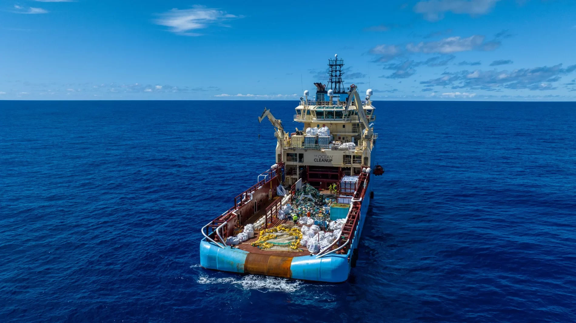 Imagem de grande embarcação no oceano com carga volumosa.