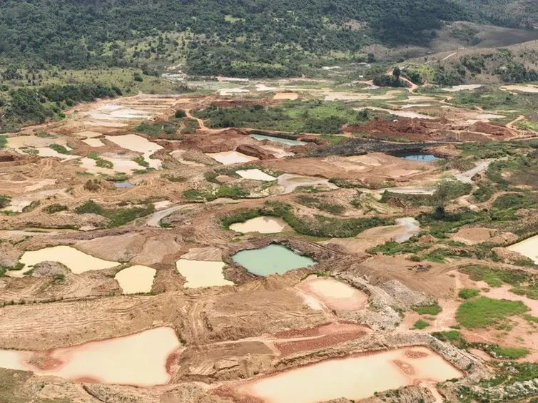 Imagem de uma vista aérea de uma grande mina a céu aberto.