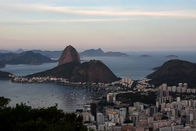 Imagem de uma cidade com uma montanha ao fundo.