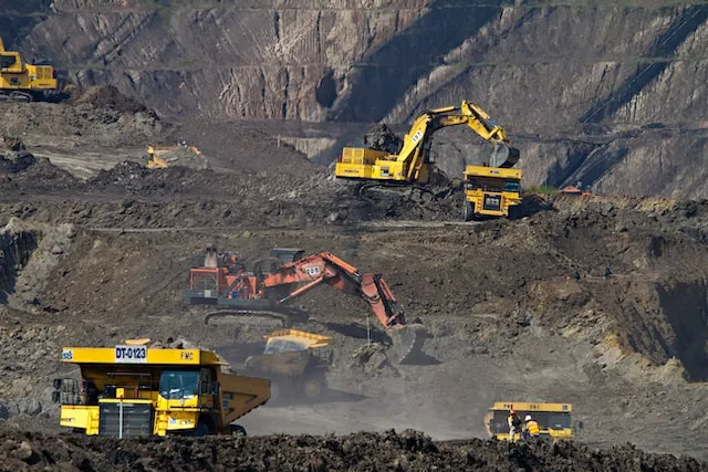 Imagem de equipamentos de construção em um campo de terra.