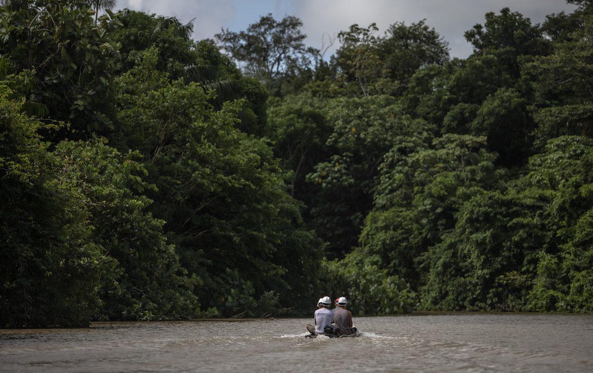 Imagem de um casal em um barco em um rio.